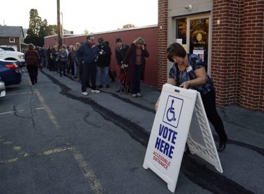An election official places a sign as voters line up outside a polling place at the Fogelsville Volunteer Fire Co., Tuesday, Nov. 8, 2016, in Fogelsville, Pennsylvania. Photo: Matt Slocum/AP Photo