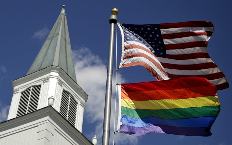 In this April 19, 2019 file photo, a gay pride rainbow flag flies along with the U.S. flag in front of the Asbury United Methodist Church in Prairie Village, Kan. Photo: Charlie Riedel/AP Photo, File