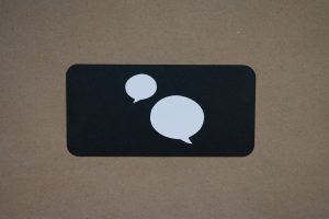 White speech bubbles on a black background rectangle.