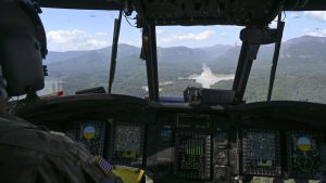 Maryland Army National Guard Chief Warrant Officer 4 Joshua Chason assesses the damage to Lake Lure inside a CH-47 Chinook helicopter for Hurricane Helene relief efforts in Asheville, North Carolina, October 5, 2024. During the mission, the team of eight Soldiers delivered pallets of baby supplies and insulin to multiple affected locations across Western North Carolina after the devastation caused by Hurricane Helene. Photo: Staff Sgt Alexandra Huettner/U.S Air National Guard