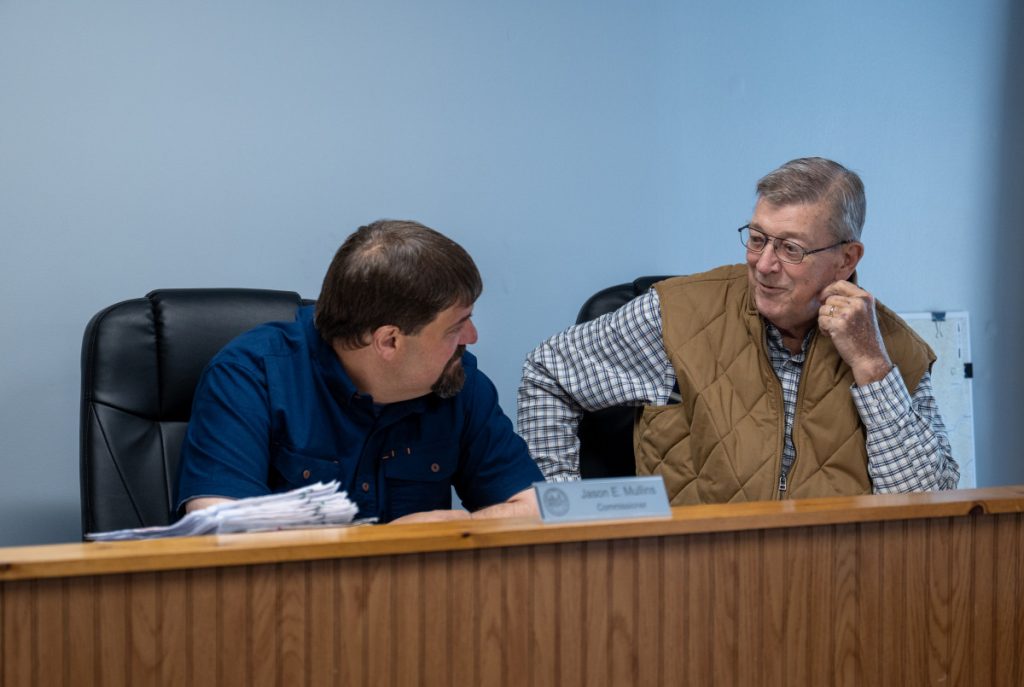 Wyoming County Commissioner Jason Mullins, left, speaks with fellow Commissioner Randall Aliiff at a meeting on April 15th, 2025. Photo by Aidan Cornue/West Virginia University