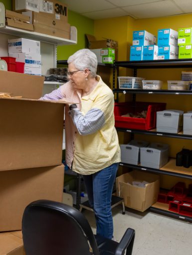 On June 6, 2025, Laura Jones goes through boxes of Easy Touch syringes to be distributed by Milan Puskar Health Right in Morgantown, W.Va., which operates one of only three syringe exchange programs in West Virginia. Photo by Ty McClung/West Virginia University