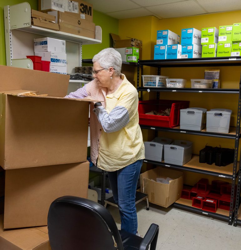 On June 6, 2025, Laura Jones goes through boxes of Easy Touch syringes to be distributed by Milan Puskar Health Right in Morgantown, W.Va., which operates one of only three syringe exchange programs in West Virginia. Photo by Ty McClung/West Virginia University